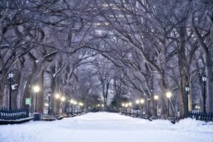 Nieve en Nueva York Navidad con mapa morado del pronóstico y el skyline de la ciudad bajo condiciones invernales.