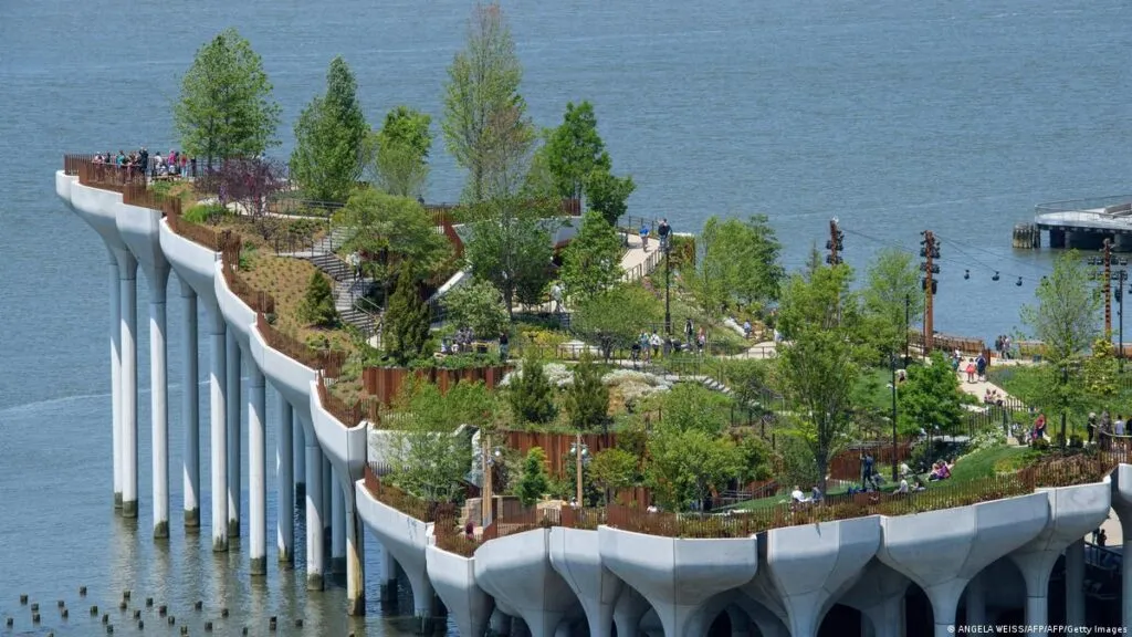 Vista panorámica de Little Island Nueva York con jardines elevados y el río Hudson al fondo en Manhattan.