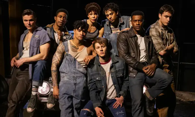 Escena inspirada en The Outsiders Broadway con ambiente teatral moderno y público en Nueva York