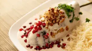 Un chile en nogada servido en un restaurante mexicano con el skyline de Nueva York al fondo.