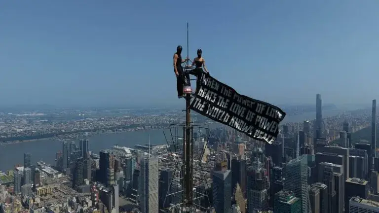 Escaladores despliegan una pancarta en la antena del Empire State Building en Nueva York.