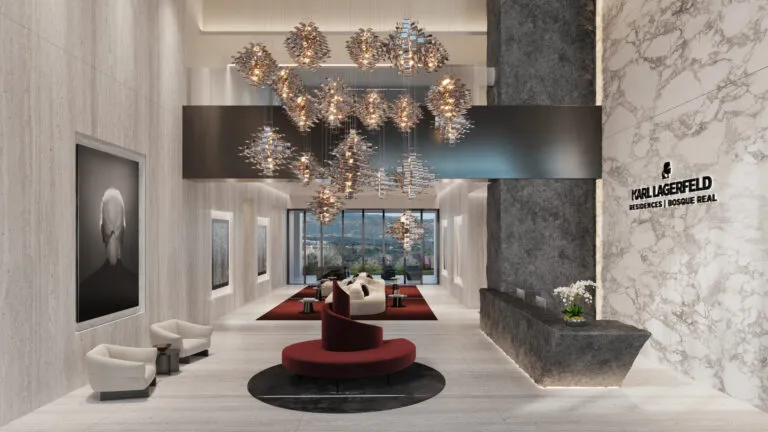 Lobby de Karl Lagerfeld Residences en Bosque Real, con lámparas escultóricas, acabados de mármol, mobiliario contemporáneo y el logotipo de la firma.