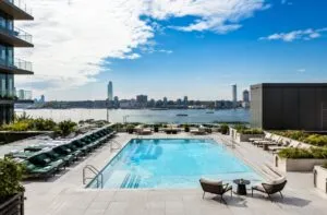 Interior de un departamento moderno de lujo en Chelsea, Manhattan, con sala amplia, cocina equipada y grandes ventanales.