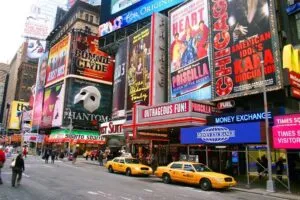 una calle comercial de Manhattan con tiendas, peatones y escaparates.