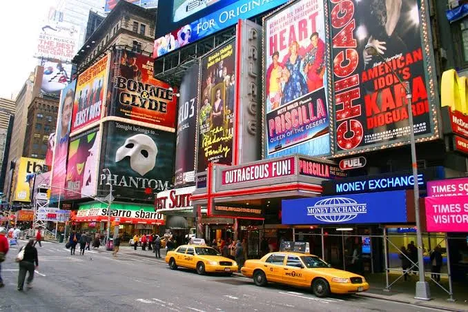 una calle comercial de Manhattan con tiendas, peatones y escaparates.